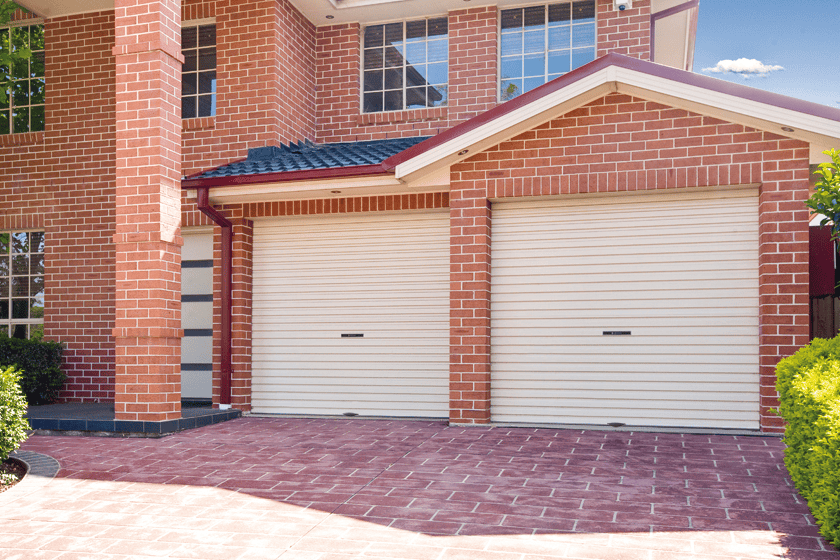 Double garage roller doors on a modern brick home, installed by SAMT Garage & Gate Automation in Prestons, New South Wales, Australia.