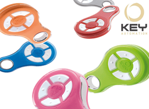 Variety of Key Automation wireless remotes in orange, red, blue, pink, green, and gray, with company logo, shown in Prestons, New South Wales, Australia.